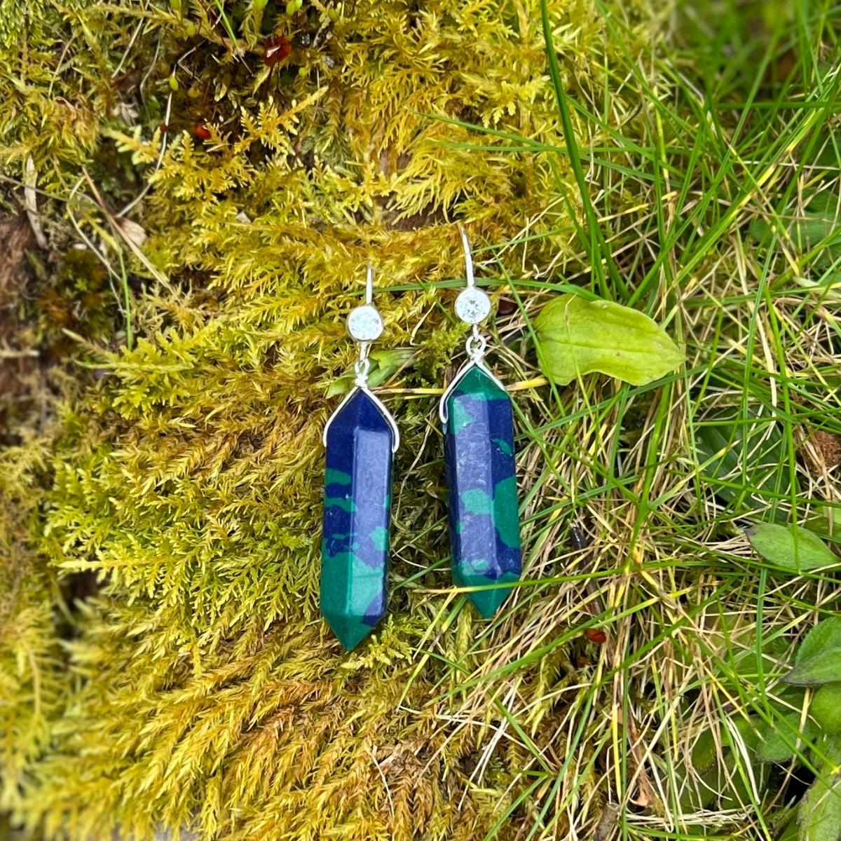 The Peaceful Waters Chrysocolla Earrings are a stunning pair of earrings that feature two polished Chrysocolla stones. Chrysocolla is known for its calming and soothing energy, promoting inner peace and tranquility.