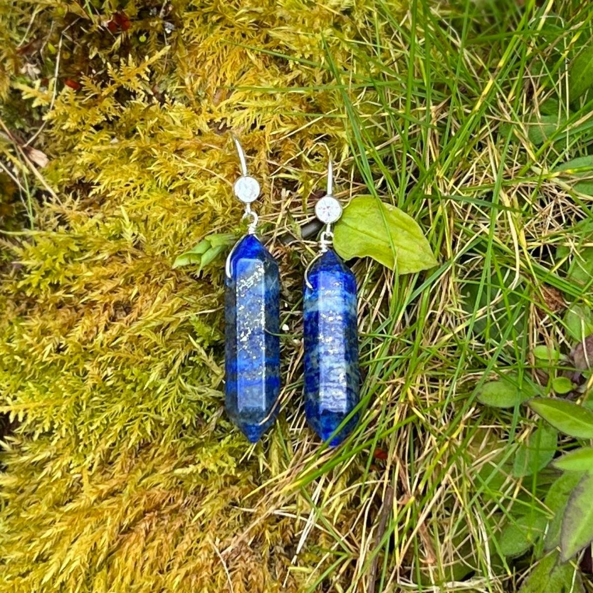 The Lapis Lazuli Meditation Earrings are a stunning pair of earrings that combine natural beauty with spiritual significance. Each earring features a double-pointed Lapis Lazuli stone, which is known for its deep blue color and unique veining. 