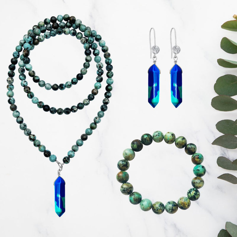 The Peaceful Waters Necklace, Earring and Bracelet Jewelry Set is created with Chrysocolla and African Turquoise. These bule and green gemstones bring you calming and soothing energy, promoting inner peace and tranquility.