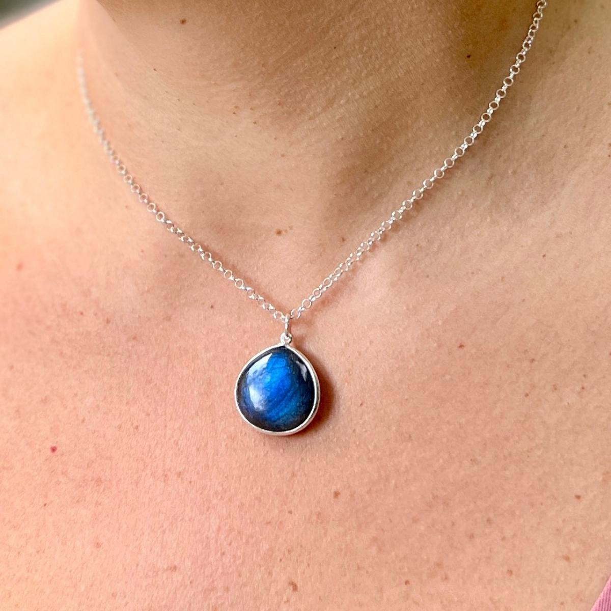 The Magic Mindset Labradorite Necklace is a beautiful sterling silver necklace that features a stunning, 1 inch teardrop-shaped labradorite stone as its centerpiece. Labradorite is a unique crystal known for its iridescent hues and ability to enhance positivity, intuition and spiritual awareness.