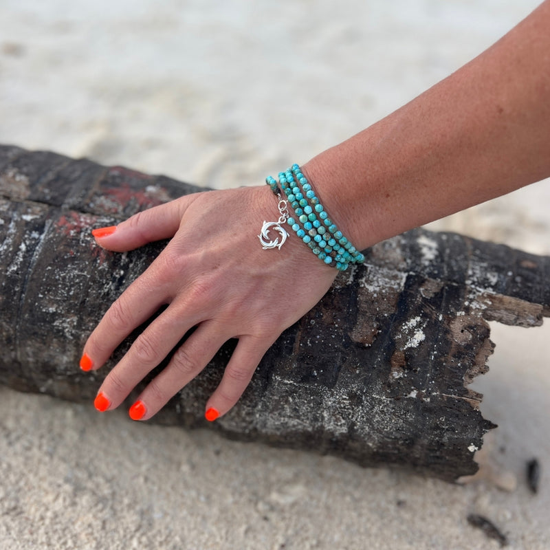 The Dolphin Dance Wrap Bracelet embodies a captivating blend of spirited grace, capturing the dynamic allure of the ocean.