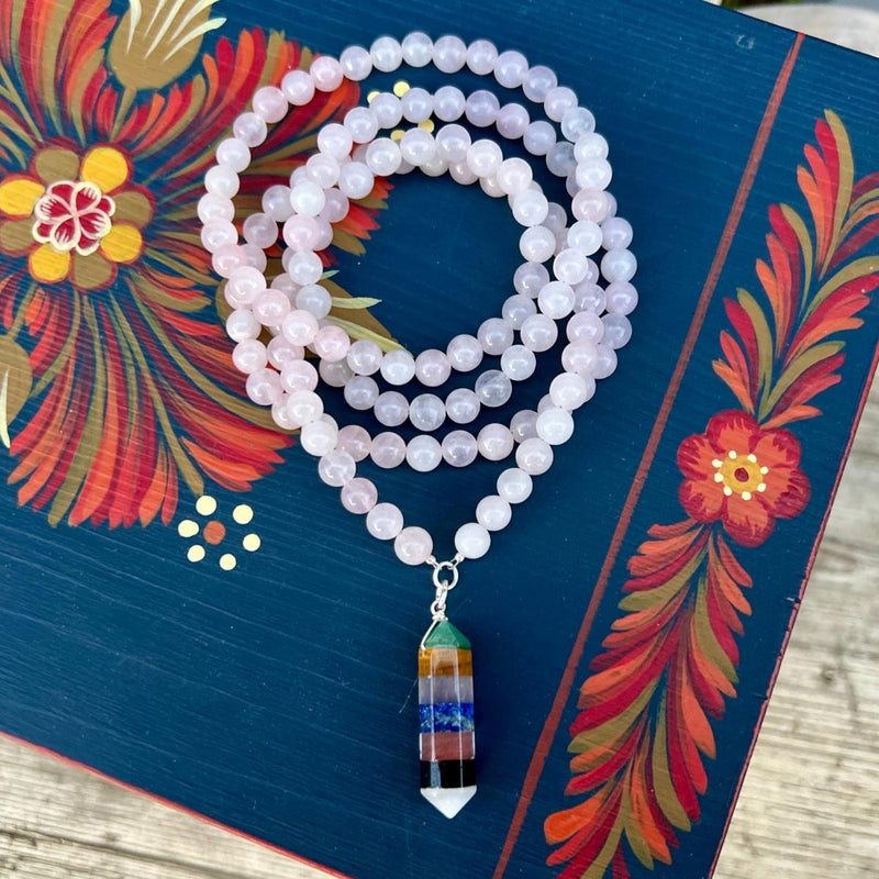 Chakra Balancing Necklace. Deeply meditative to wear, this Chakra Balancing Necklace brings the body’s seven main Chakras into alignment. Rose quartz is an excellent heart-healing gemstone. The colorful gemstones on the centerpiece correspond to the seven different chakras.