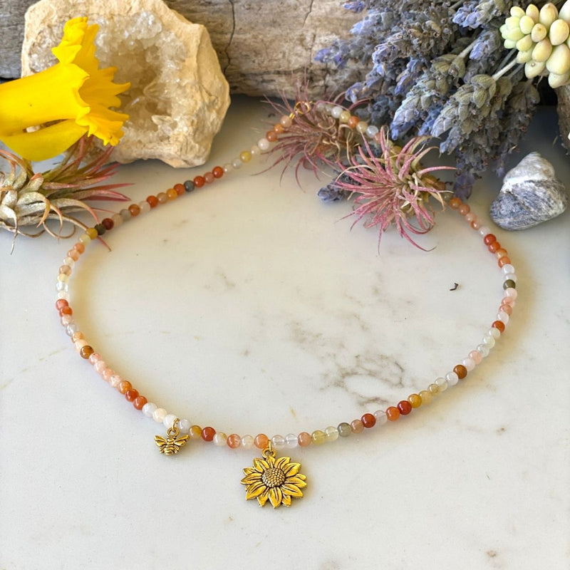 Bee Happy Necklace with colorful Jade. The bracelet is adorned with a playful bee and sunflower charms to help you live happy.