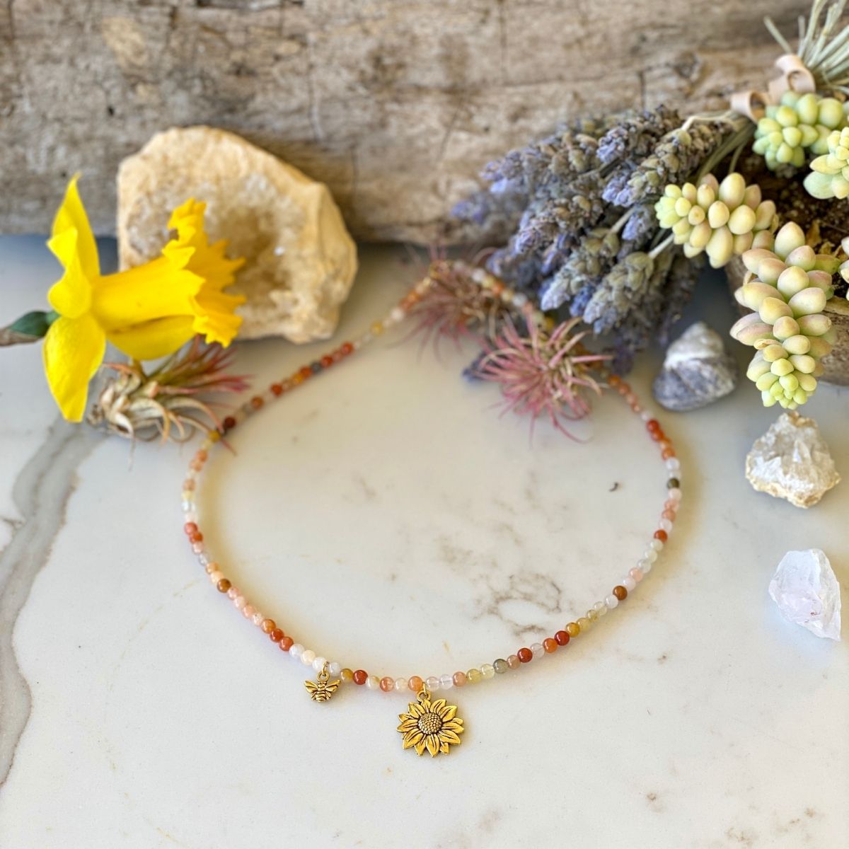 Bee Happy Necklace with colorful Jade. The bracelet is adorned with a playful bee and sunflower charms to help you live happy.