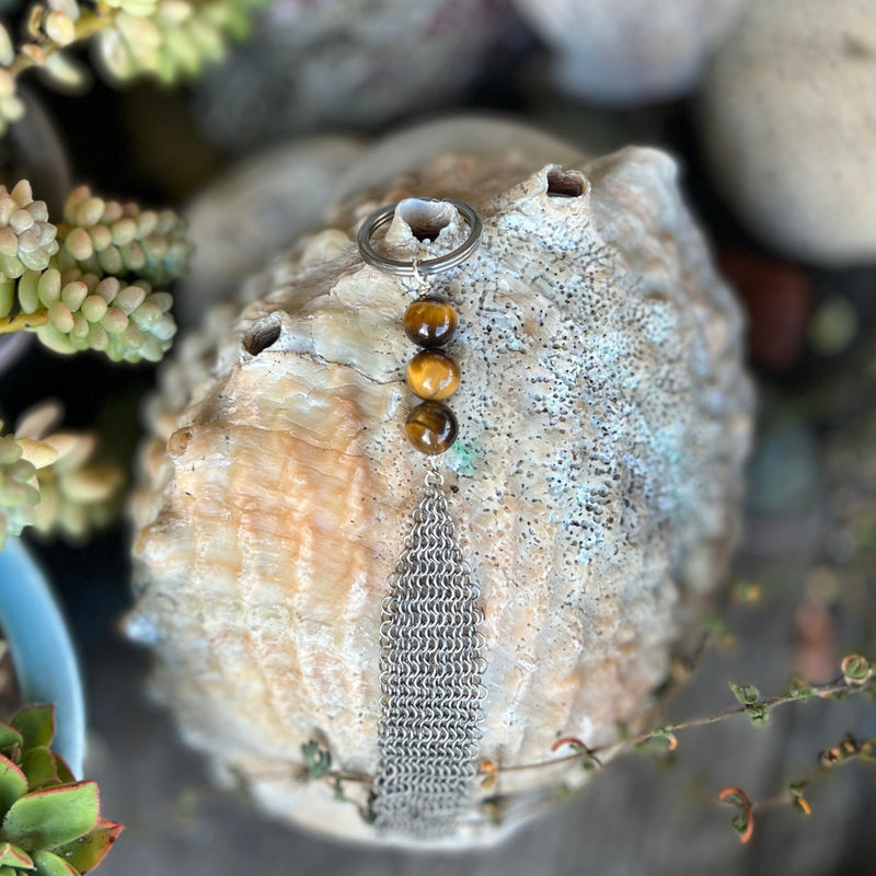 Neptunic SharkSuit Keychain with Tiger Eye - Sustainable Fashion for Ocean Lovers. Get Grounded with this Tiger Eye Keychain. Stainless Steel Chainmail connects to beautiful gemstone beads. This unisex keychain is  constructed with unused pieces of Stainless Steel Mesh from Neptunic SharkSuits. 