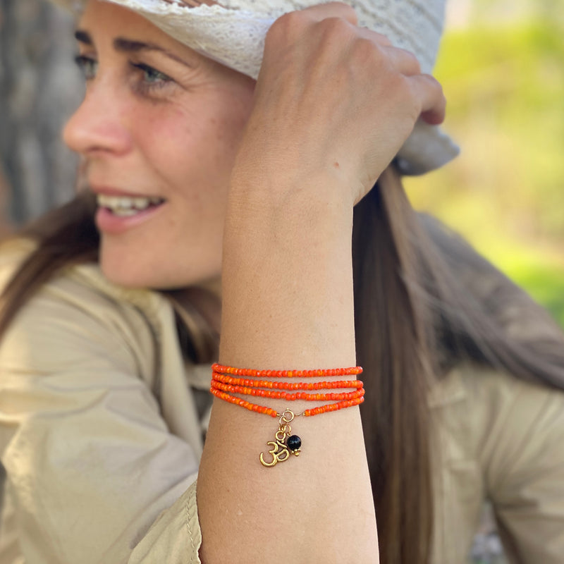 Orange Crystal Wrap Bracelet for Creativity with Ohm and Onyx Charms. Wear it on or off the yoga mat. Orange Yoga inspired bracelet and necklace all in one. I love wearing this piece as both a bracelet and a mala/necklace. The brightness of the color immediately shifts my mood to something lighter, happier.
